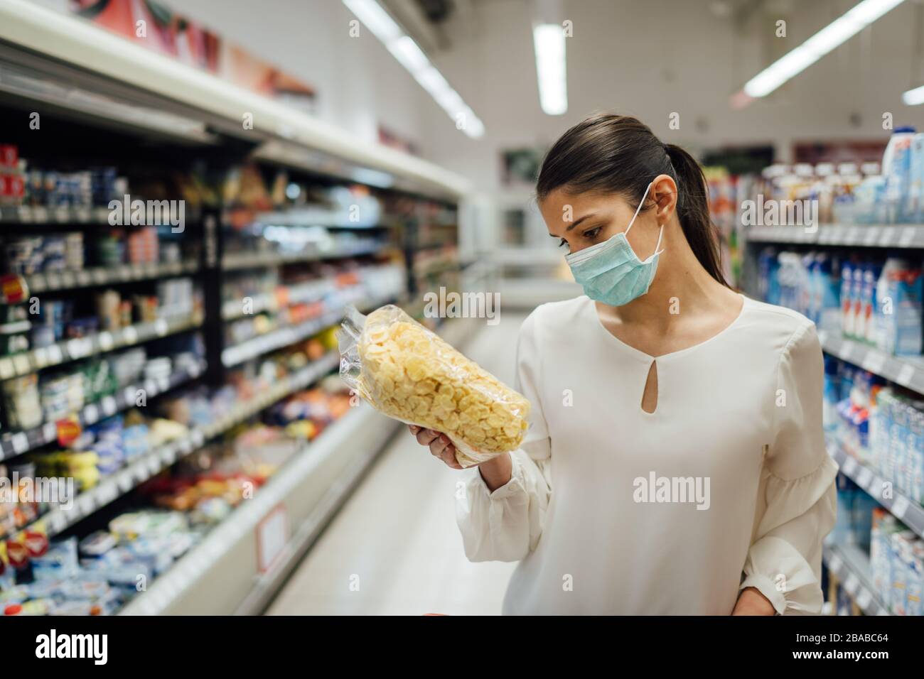 Shopping pendant une épidémie.Acheteur portant un masque de protection.épicerie de ménage non périssables et Smart acheté.préparation de quarantaine pandémique.D Banque D'Images