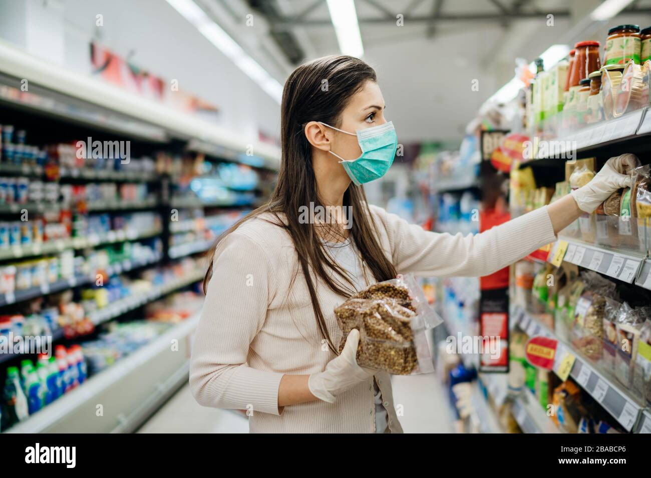 Shopping pendant une épidémie.Acheteur portant un masque de protection.épicerie de ménage non périssables et Smart acheté.préparation de quarantaine pandémique.D Banque D'Images