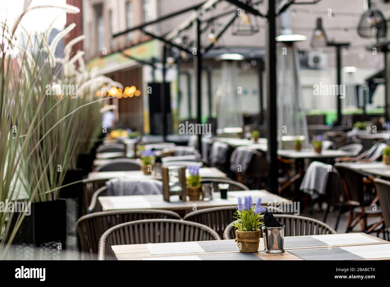 Table en bois avec serviettes et condiments dans un restaurant rustique complètement vide avec maintenant les gens et les clients pendant covid 19 corona virus pandémique shu Banque D'Images