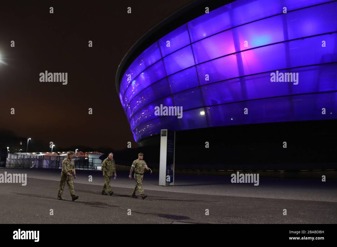 Le personnel militaire passe devant l'Hydro SSE de Glasgow, qui est illuminée en bleu par un geste de grâce au personnel du NHS qui s'efforce de combattre le coronavirus. Un hommage national pour les héros de la santé de première ligne a lieu dans tout le Royaume-Uni avec un grand nombre d'applaudissements sur les portes, les fenêtres et les balcons jeudi à 20:00. Banque D'Images