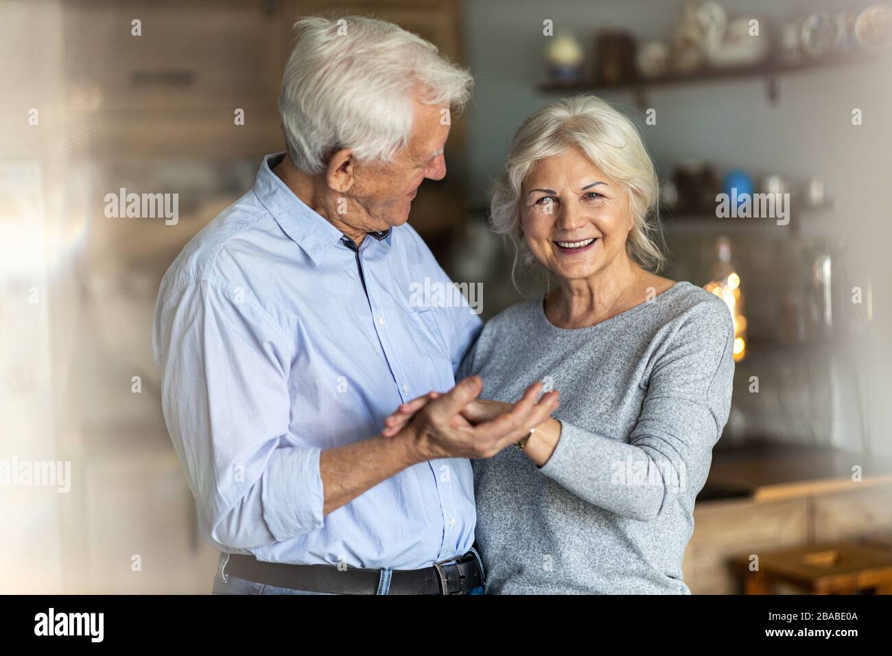 Heureux couple senior embrassant dans leur maison Banque D'Images