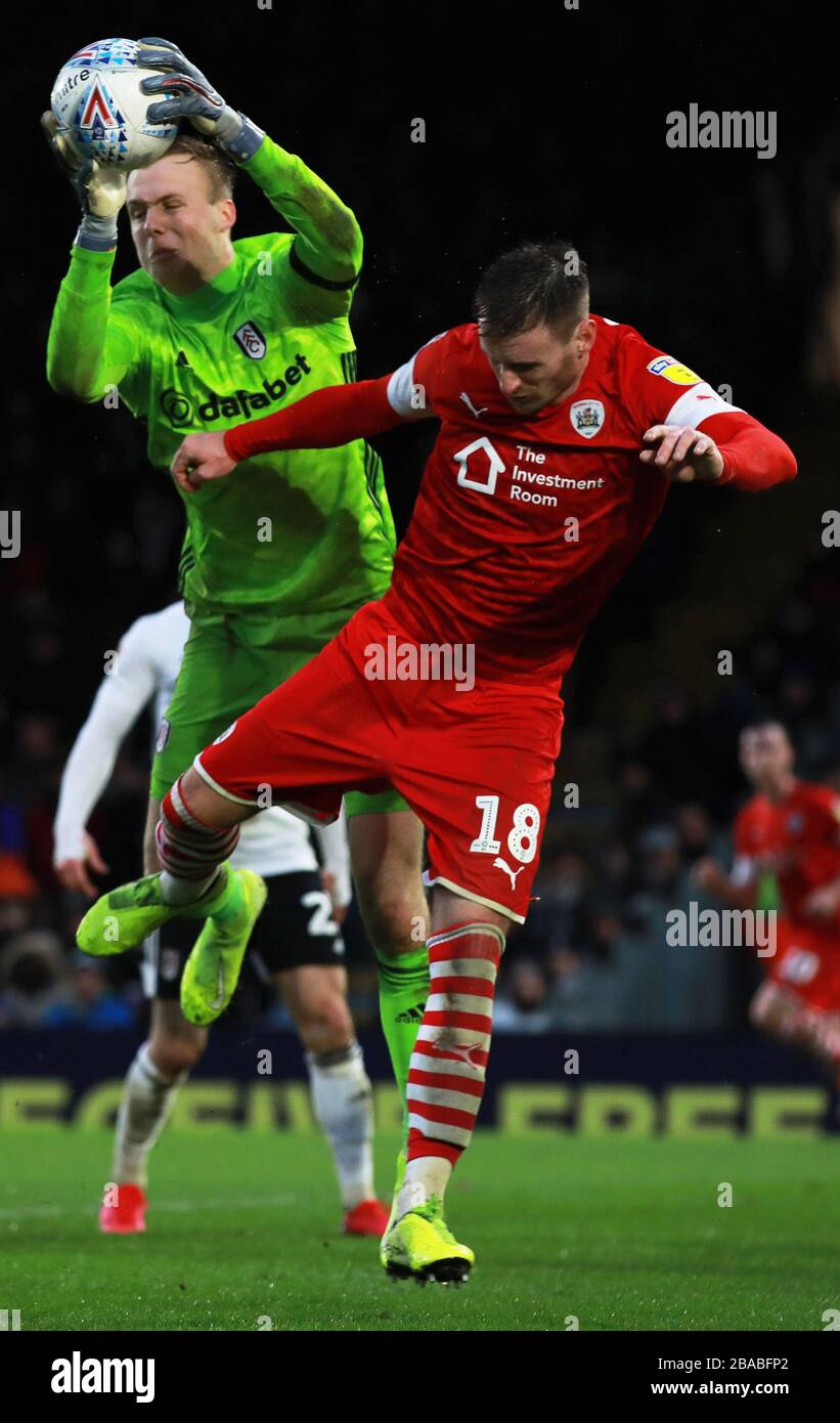 Marek Rodak de Fulham (à gauche) et Michael Sollbauer de Barnsley se battent pour le ballon Banque D'Images