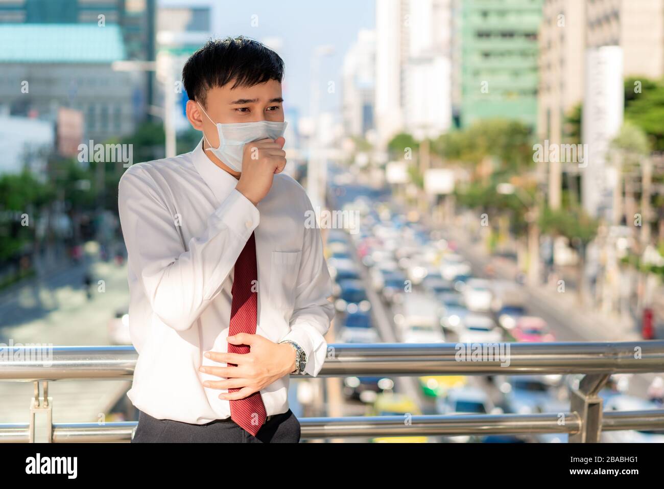Les jeunes hommes d'affaires asiatiques en chemise blanche qui vont  travailler malades de la toux portent un masque de protection empêchant la  poussière, le smog, la pollution de l'air et le COVID-1