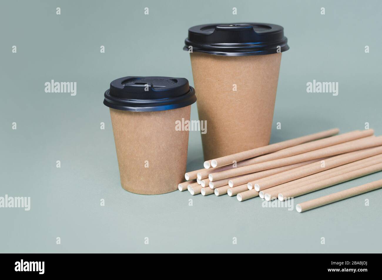 Tasses à café artisanales avec paille de papier sur fond gris. Design écologique. Zéro déchet, articles sans plastique Banque D'Images
