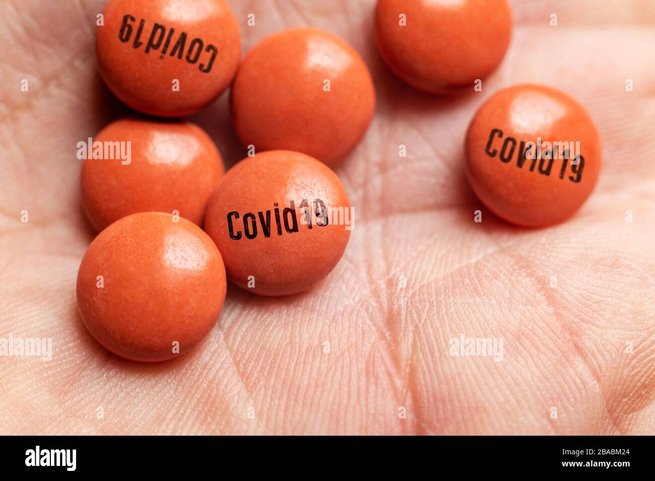 Illustration d'un traitement pour Coronavirus Covid-19, homme tenant une pilule avec étiquette Covid-19. Banque D'Images