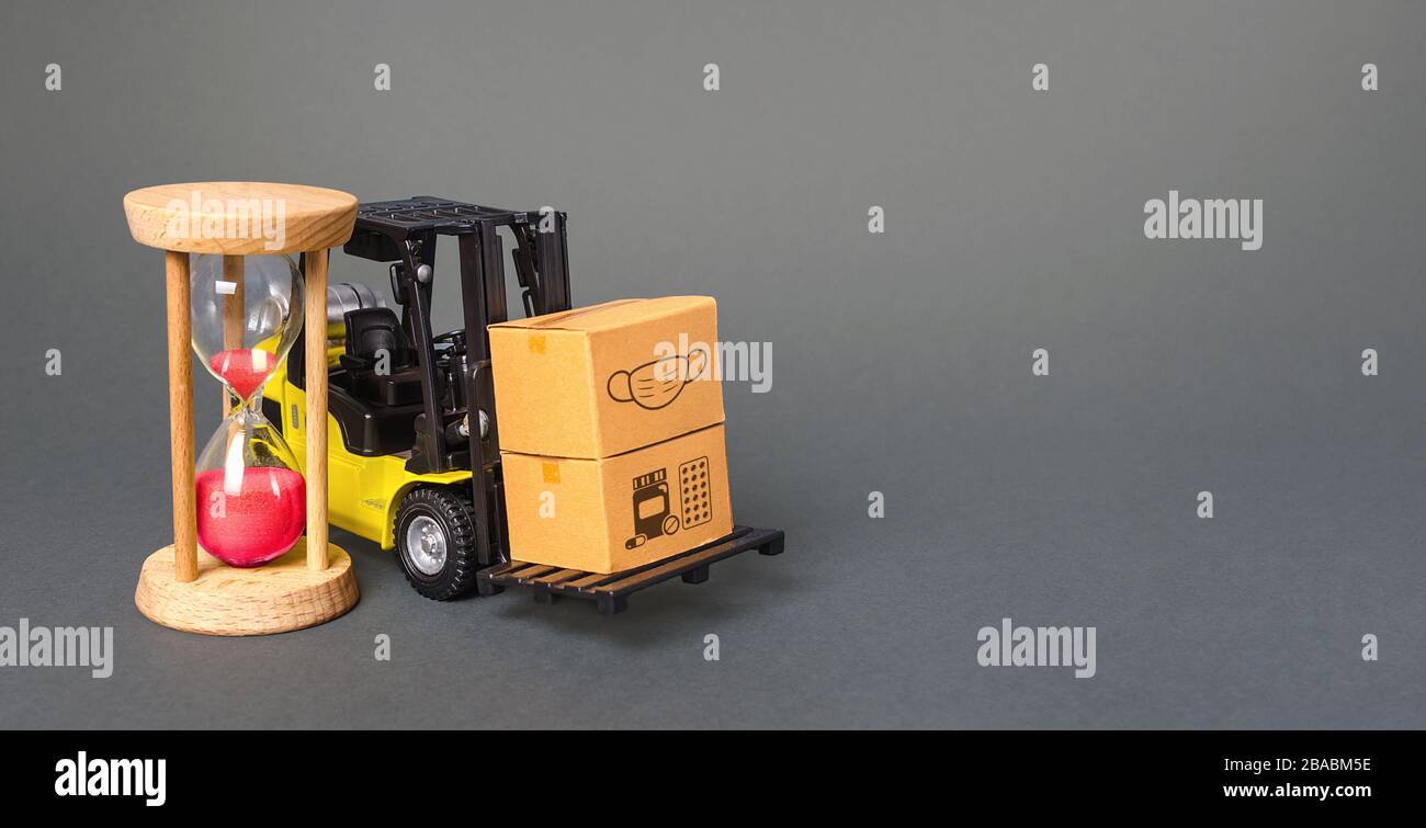 Chariot élévateur avec boîtes et sablier. Livraison urgente de médicaments et de masques de protection médicale. Approvisionner les hôpitaux et les populations pour arrêter la propagation de COVID-19 Banque D'Images