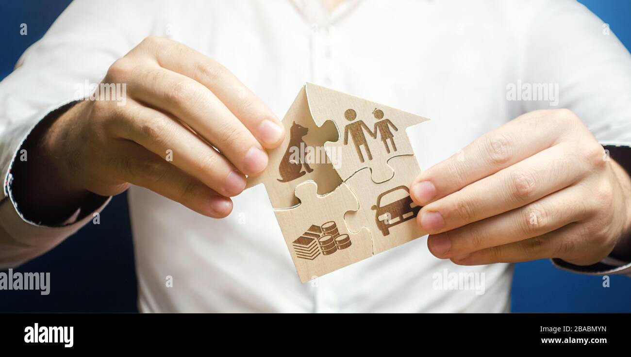 L'homme construit une maison de puzzle. Maison de rêve. Acheter ou construire votre propre logement résidentiel avec prêt hypothécaire, amélioration des conditions de vie. Collecter Banque D'Images