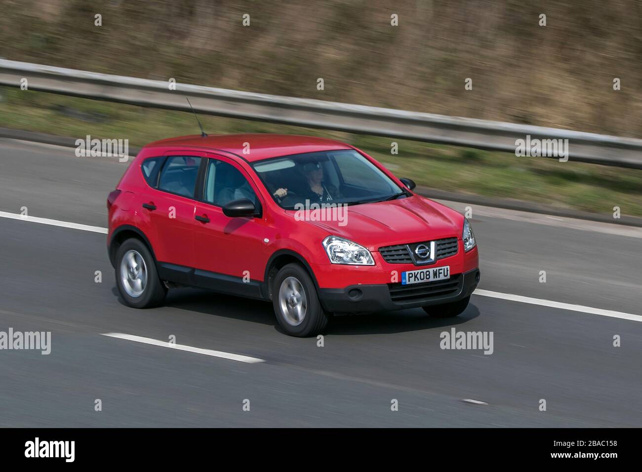 PK08WFU 2008 Nissan Qashqai Visia DCI Red car Diesel 2 RM conduisant sur l'autoroute   près de Preston dans Lancashire, au Royaume-Uni Banque D'Images