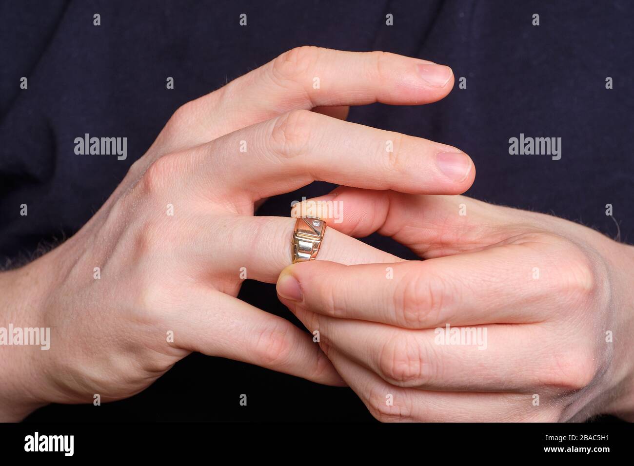 Un homme prend un anneau de mariage d'un doigt de sa main. Gros plan. Banque D'Images