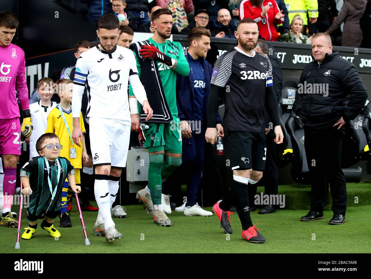 Le capitaine du comté de Derby, Wayne Rooney (à droite) et le capitaine de Swansea City, Matt Grimes, dirigent leurs équipes hors du tunnel et sur le terrain avant le début du match Banque D'Images