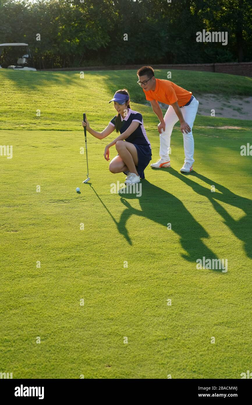 Le terrain de coaching de la jeune femme pour jouer au golf Banque D'Images