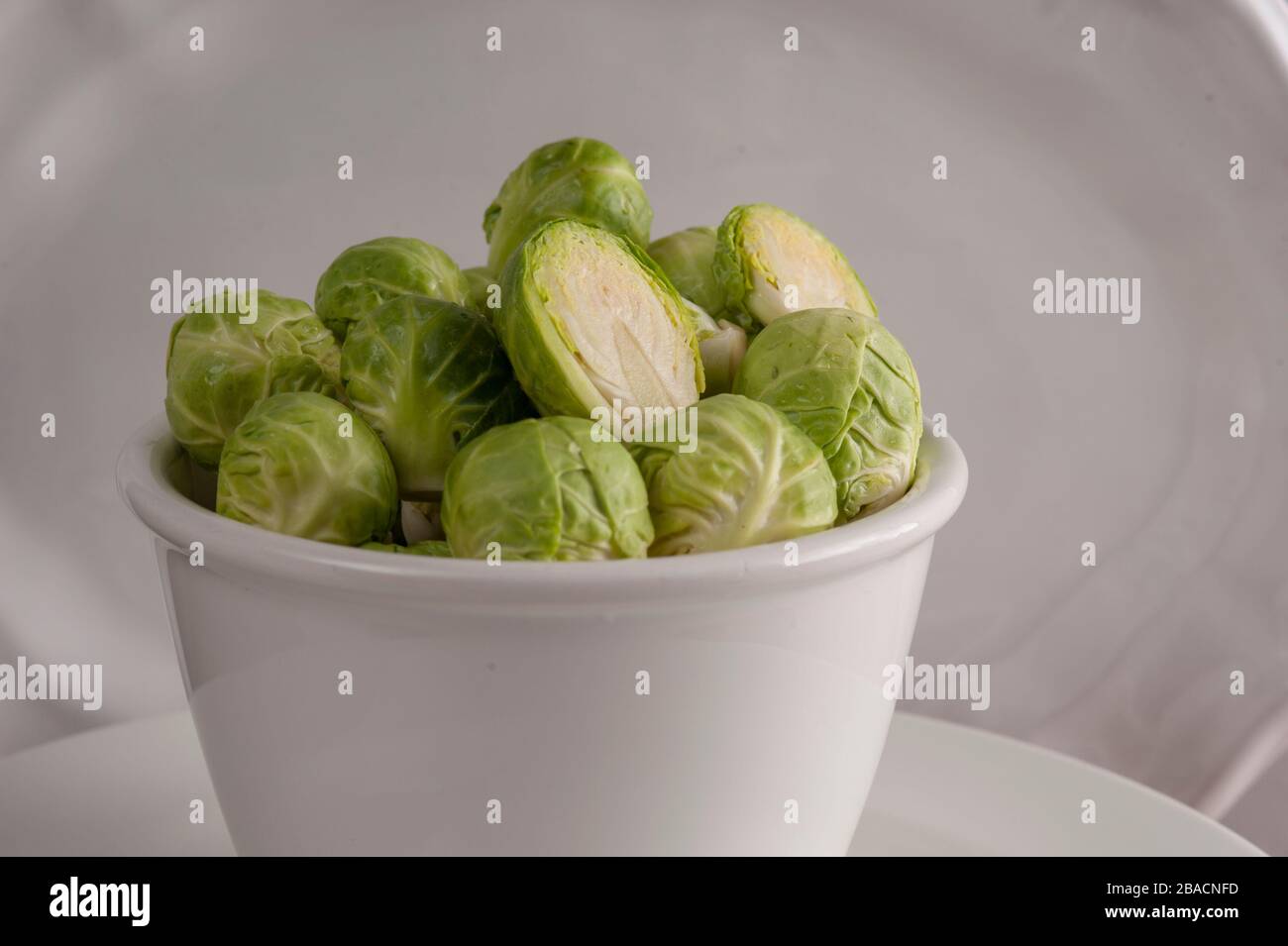 Petit bol blanc rempli de choux de bruxelles lavés. Banque D'Images