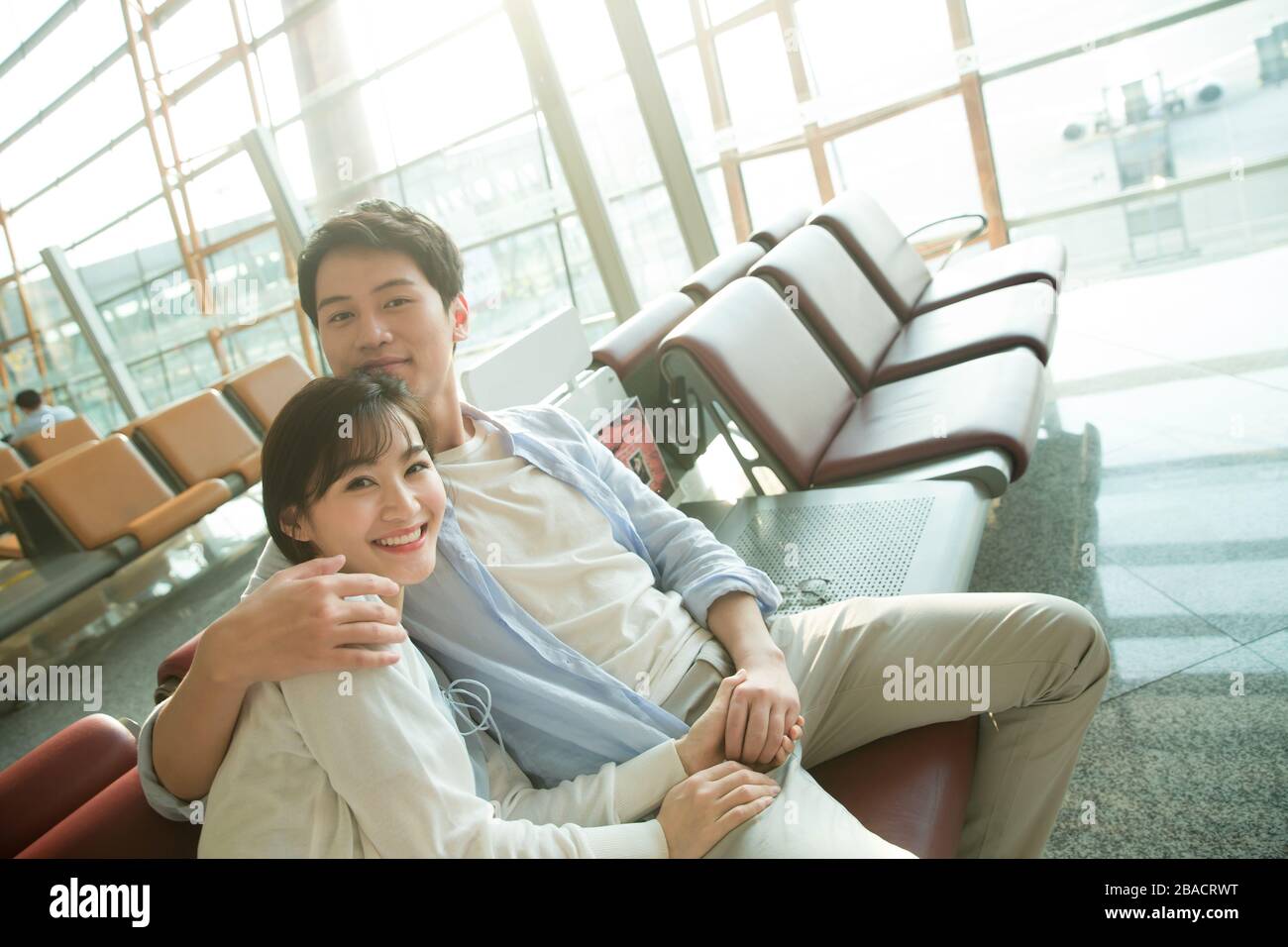 Le jeune couple assis dans le salon de l'aéroport Banque D'Images
