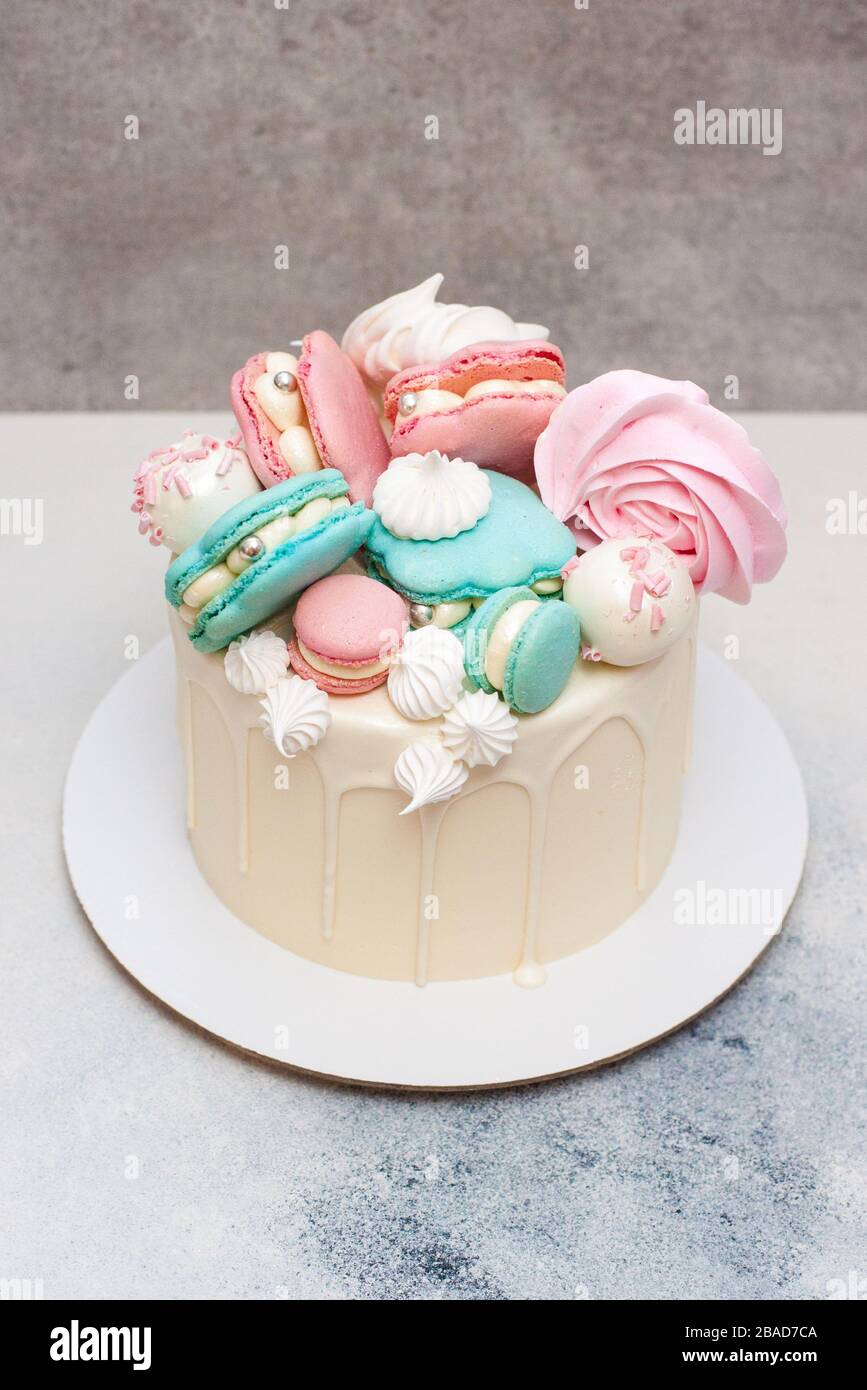 Gâteau blanc élégant avec coquilles de mer macarons, chocolat et décoration meringue Banque D'Images