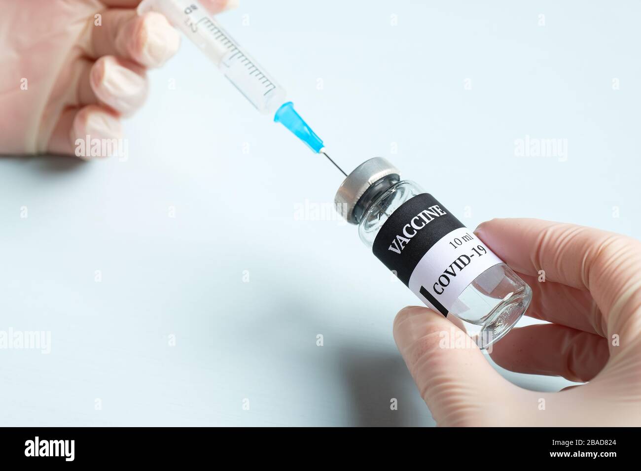 Mains dans des gants médicaux contenant le flacon et la seringue de vaccin Coronavirus COVID-19, vue rapprochée Banque D'Images