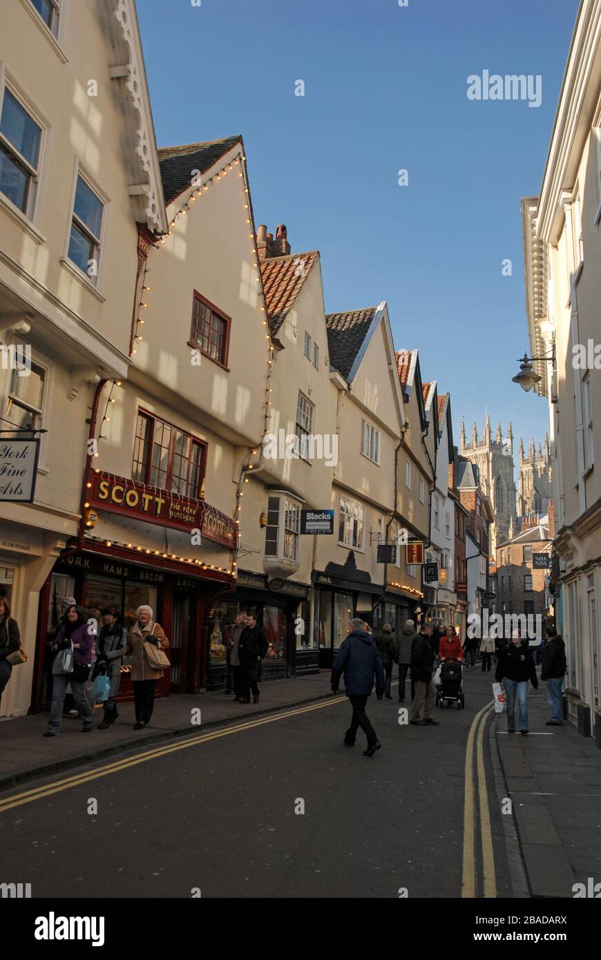 Les clients et les visiteurs de la ville animée de Low Petergate mènent à Shambles dans le vieux quartier historique de la ville de York dans le Yorkshire, en Grande-Bretagne. Une rue Banque D'Images