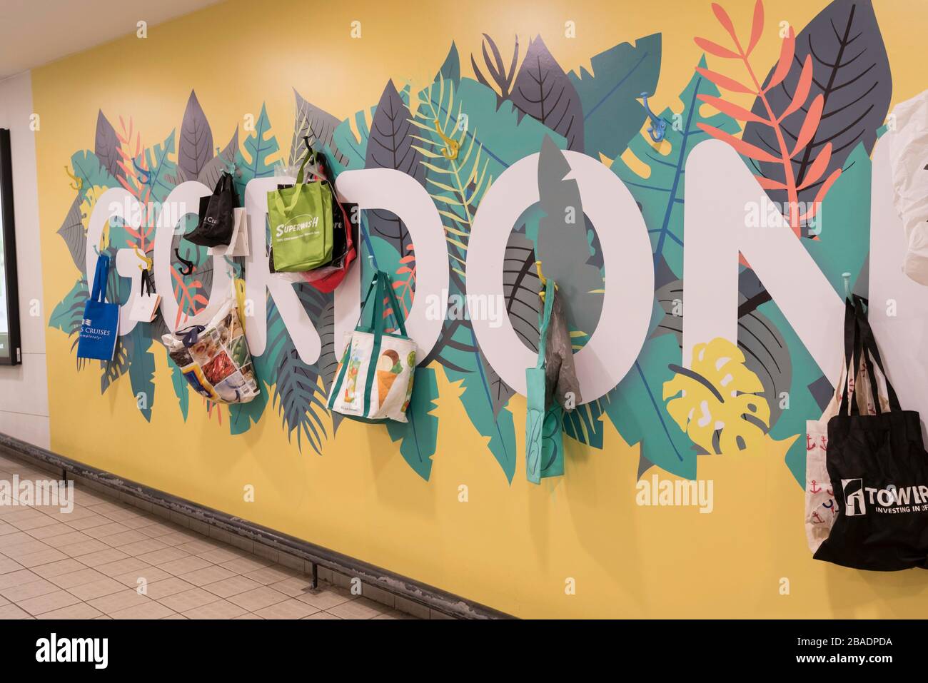 Des sacs de shopping réutilisables sont accrochés sur un mur à l'entrée d'un centre commercial pour les personnes qui ont oublié le leur dans la banlieue de Sydney de Gordon en Australie Banque D'Images