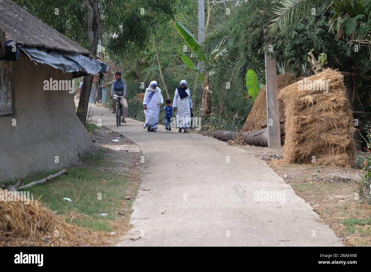 Missionnaires de la Charité - mère Teresa religieuses marchent avec l'enfant à Chunakhali, Bengale Ouest, Inde Banque D'Images