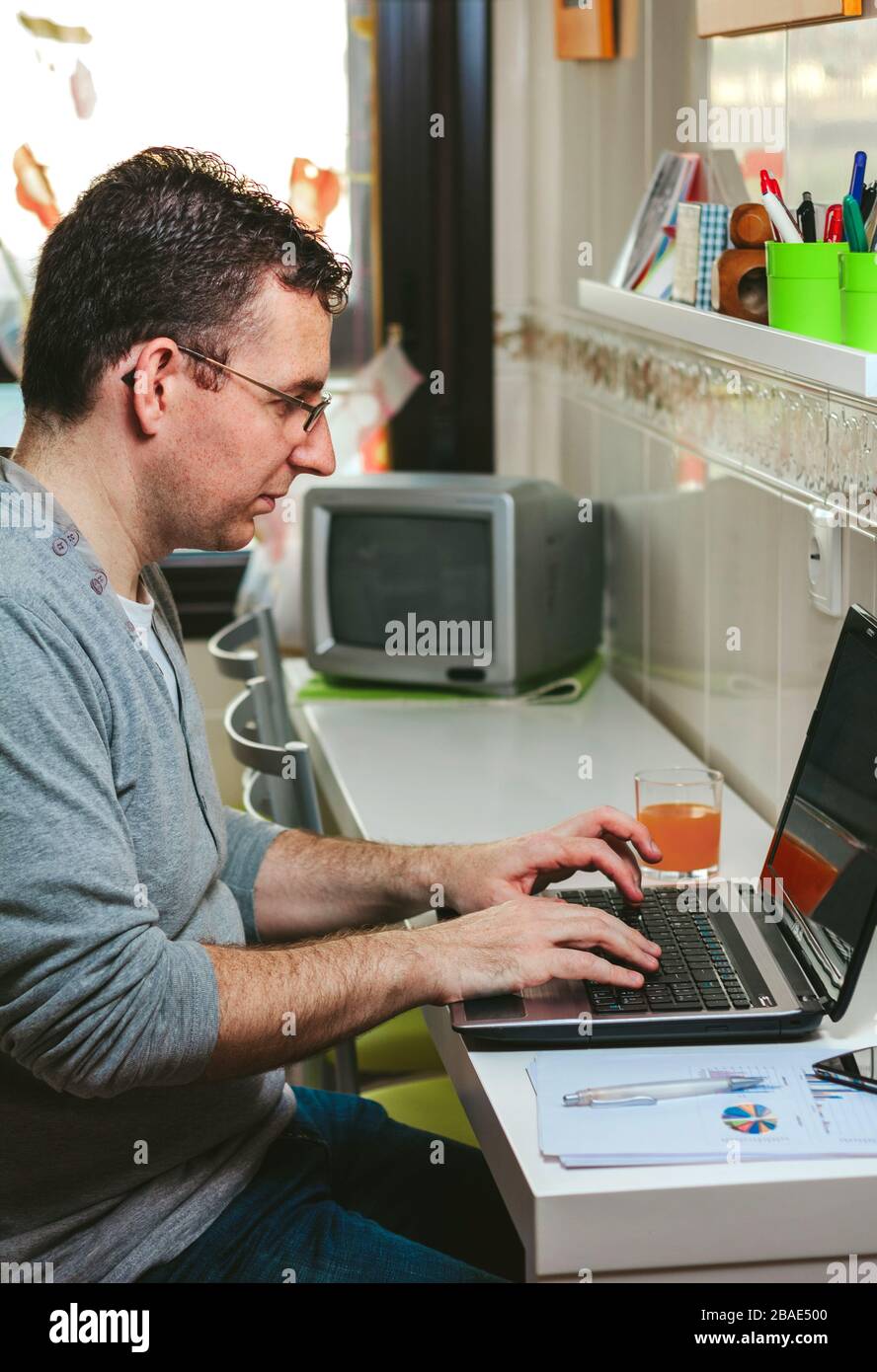 Homme travaillant à la maison avec un ordinateur portable Banque D'Images