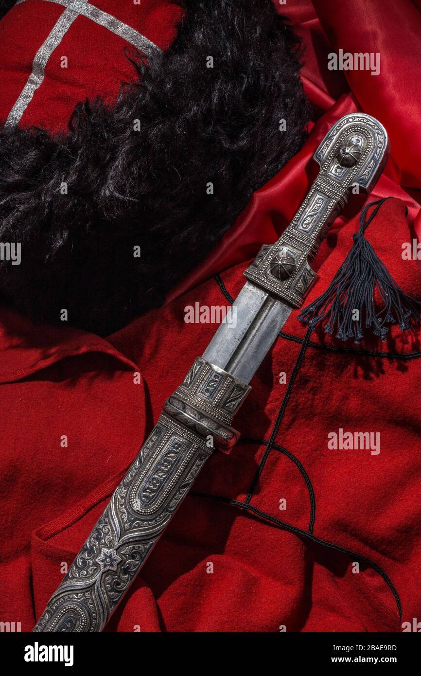 Bel exemple de dagger caucasien sur fond de bossack rouge. XIXe siècle (époque des guerres russo-caucasiennes (1816-1864)). Russie Banque D'Images