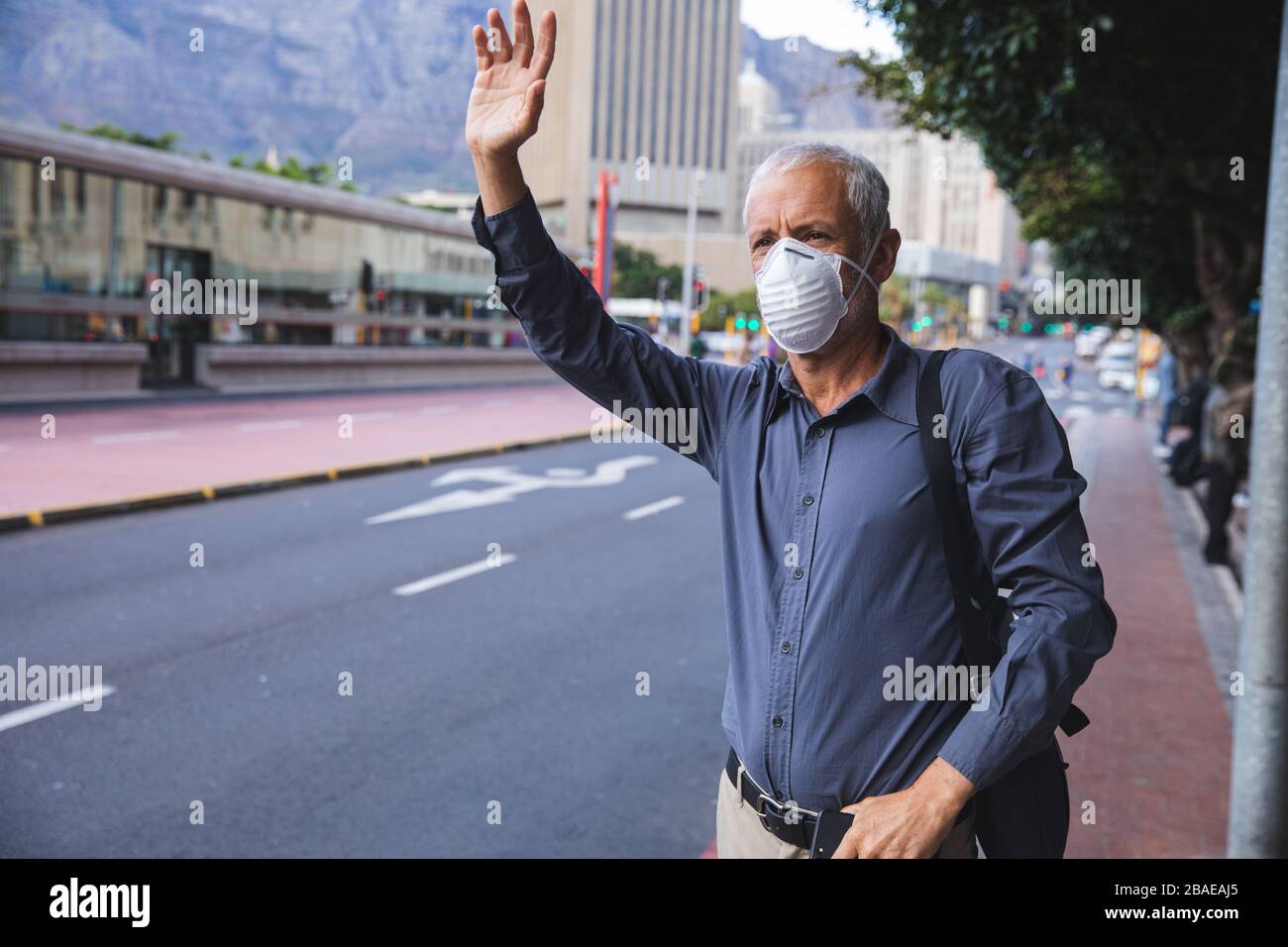 Homme d'âge moyen portant un masque Covid 19 au coronavirus lors de vos déplacements Banque D'Images