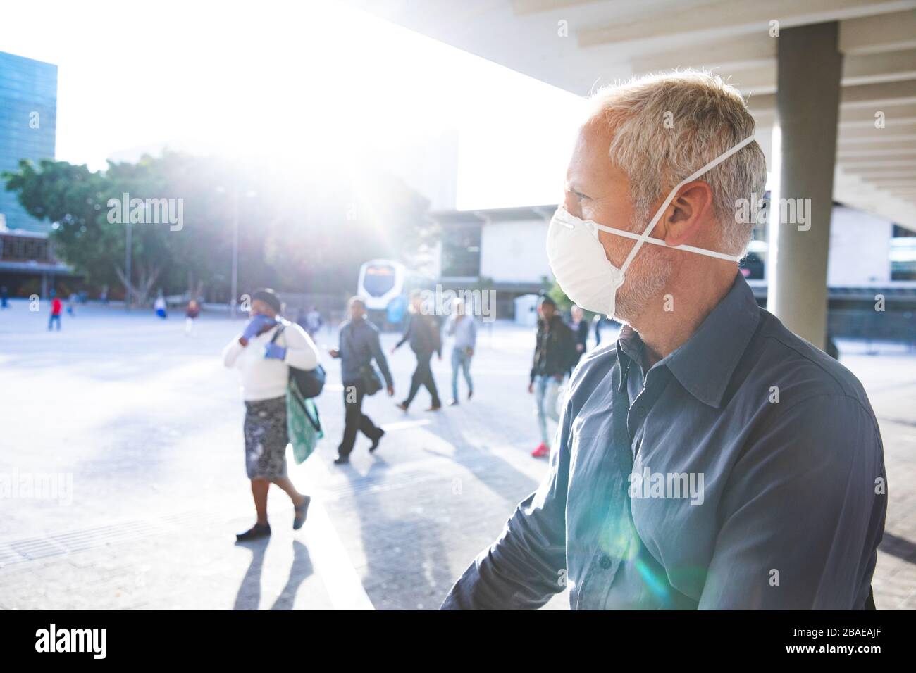 Homme d'âge moyen portant un masque Covid 19 au coronavirus lors de vos déplacements Banque D'Images