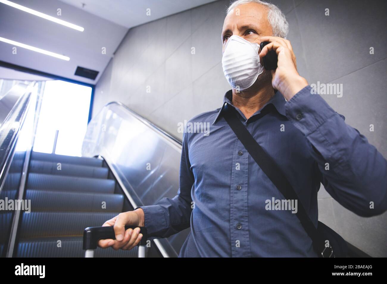 Homme d'âge moyen portant un masque Covid 19 au coronavirus lors de vos déplacements Banque D'Images Homme d'âge moyen portant un masque Covid 19 au coronavirus lors de vos déplacements Banque D'Images