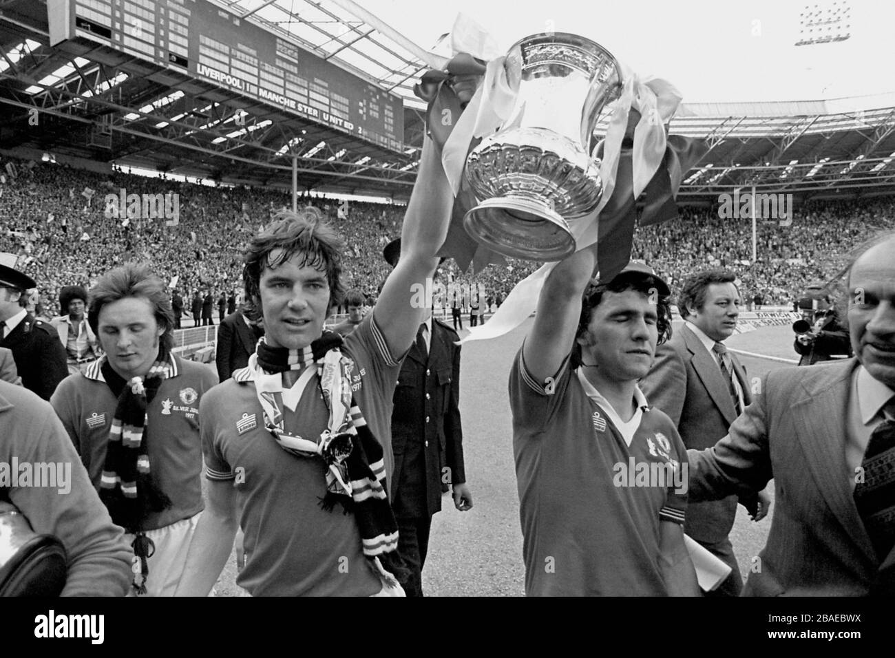 Martin Buchan (l) et Arthur Albiston (r) de Manchester United présentent la FA Cup à leurs fans jubilants Banque D'Images
