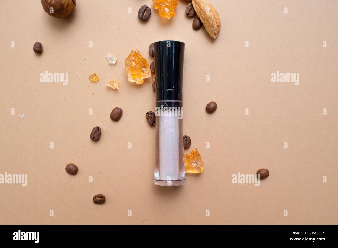 Cosmétiques pour le maquillage naturel, Concealer pour la peau sous les yeux. Fond chaud avec café à noix et fruits secs. Banque D'Images