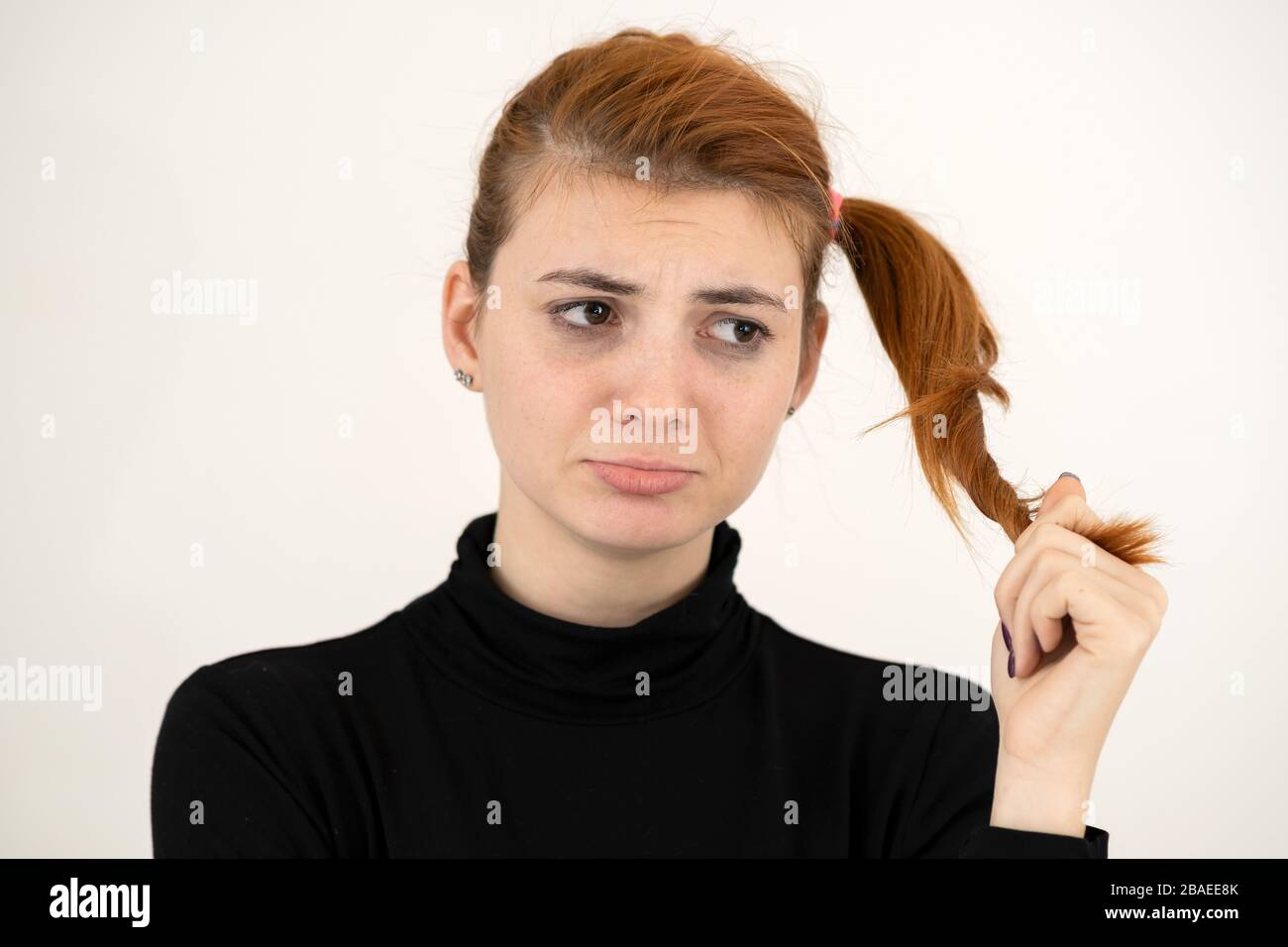 Closeup portrait of a sad redhead teenage girl with enfantillages hairstyle à offensé isolé sur fond blanc. Banque D'Images