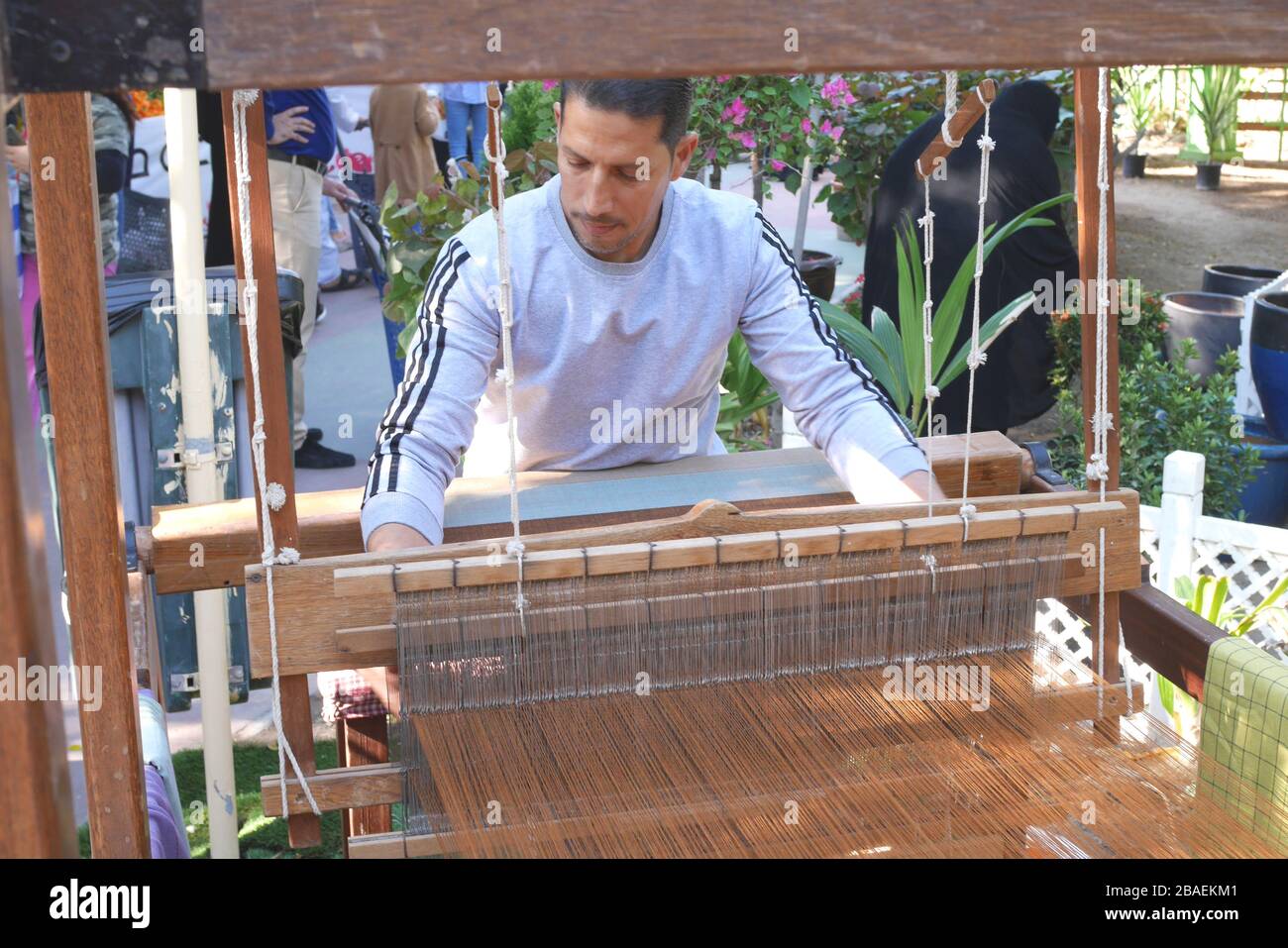 Bahraini homme tissant un tapis traditionnel sur un métier à tisser en bois, Budaiya, Royaume de Bahreïn Banque D'Images