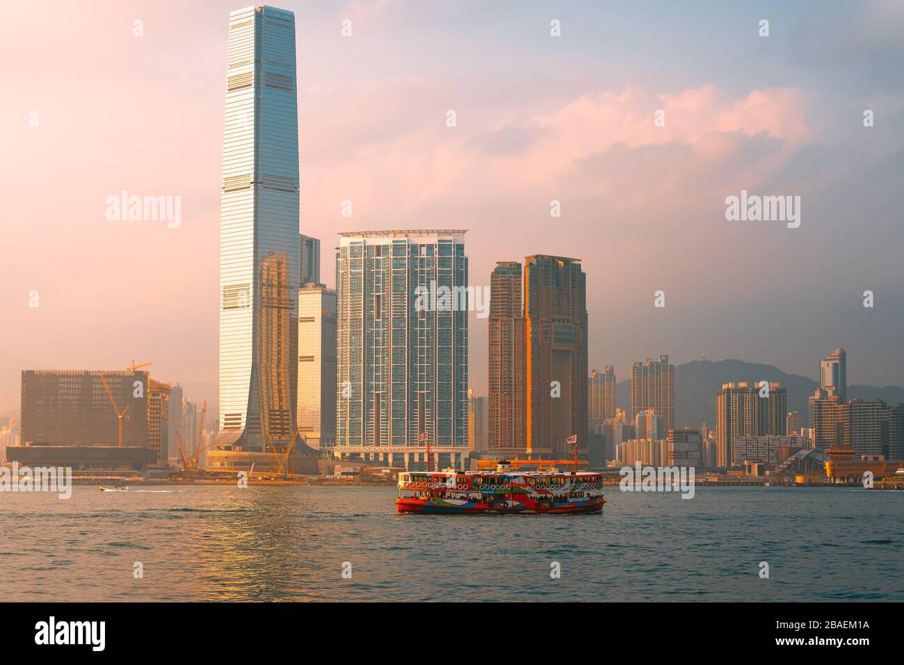 Centre, Hong Kong - 1 mars 2020: Ferry et gratte-ciel étoiles avec le coucher du soleil dans le port de Victoria Banque D'Images