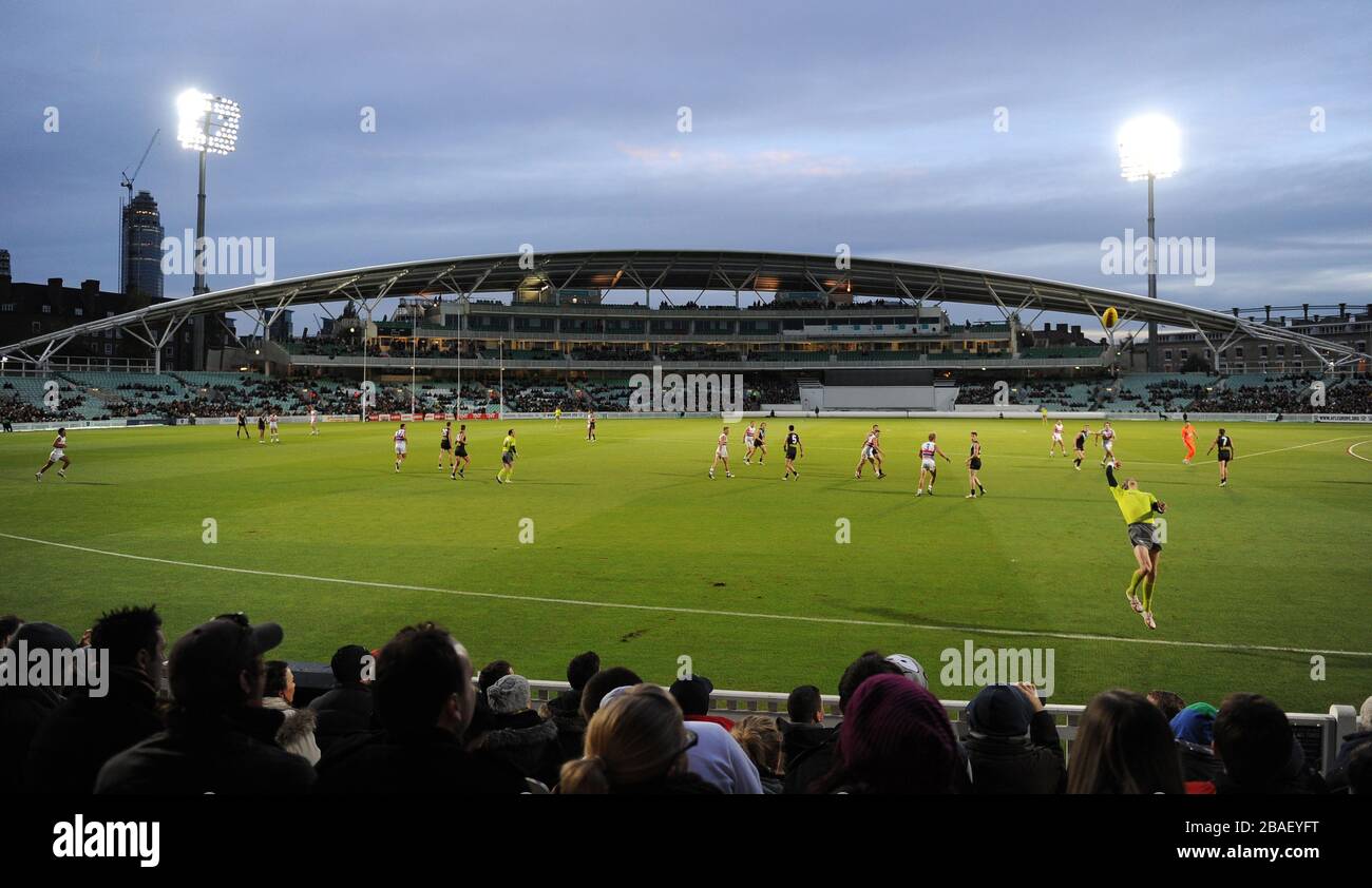 Un juge-arbitre lance le ballon de contact pour redémarrer le jeu entre Port Adelaïde et Western Bulldogs. Banque D'Images