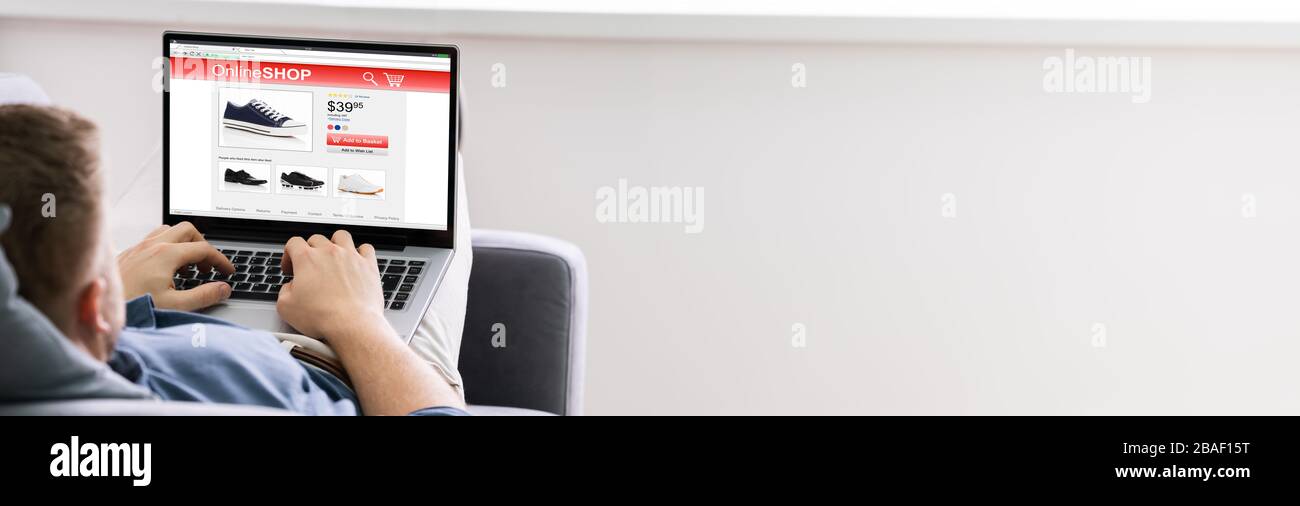 Gros plan de l'homme se détendre sur la table faire des achats en ligne sur ordinateur portable à la maison Banque D'Images Gros plan de l'homme se détendre sur la table faire des achats en ligne sur ordinateur portable à la maison Banque D'Images