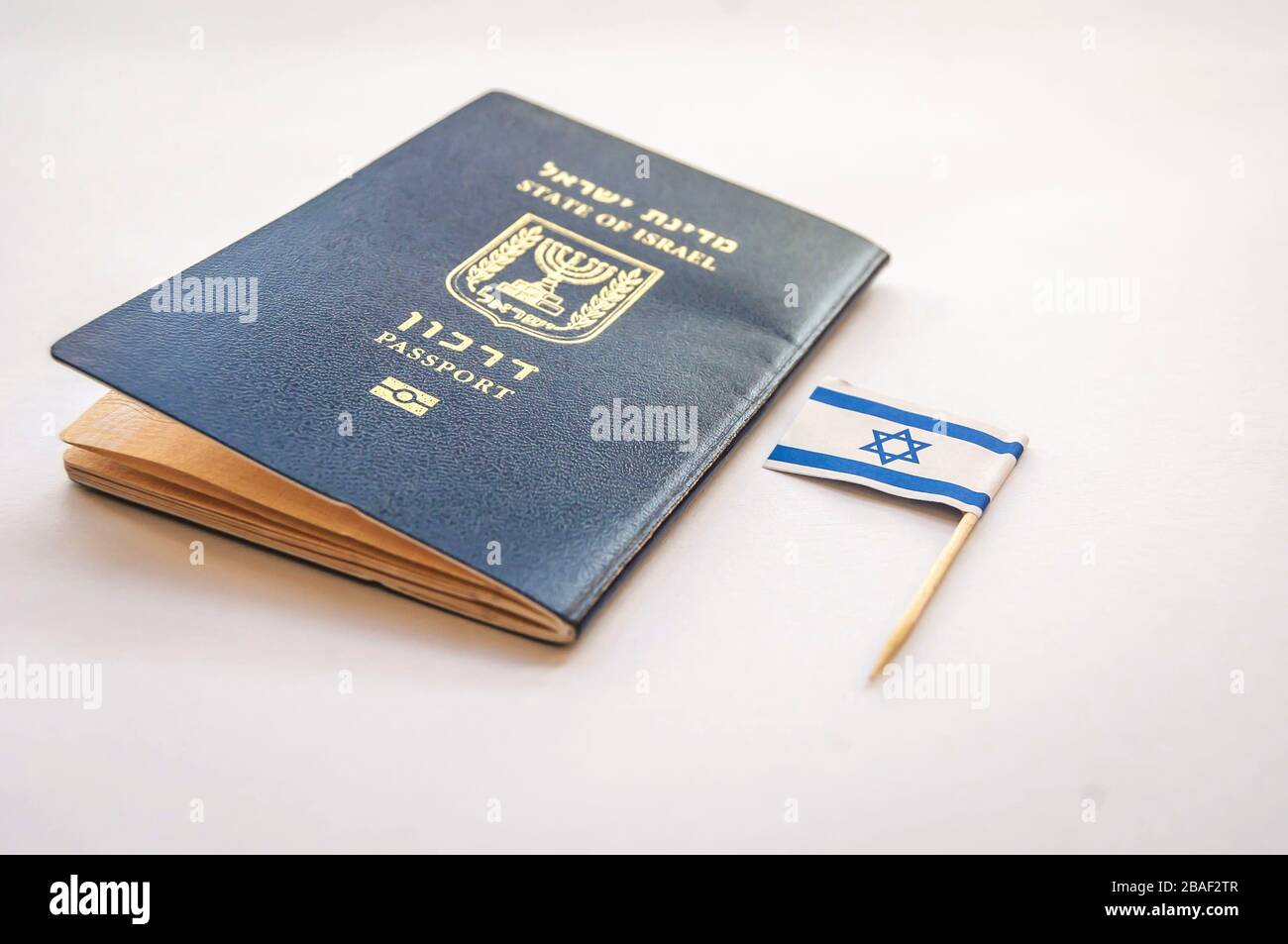 Passeport bleu de l'État d'Israël sur fond bleu clair. Concept de citoyenneté israélienne, image d'illustration du passeport « arkon » bio-métrique israélien Banque D'Images