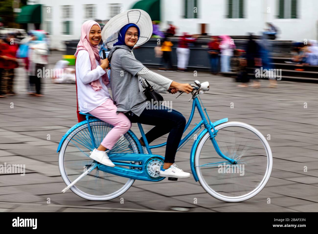 Jeunes femmes indonésiennes Cyclisme sur la place Taman Fatahillah, Jakarta, Indonésie. Banque D'Images