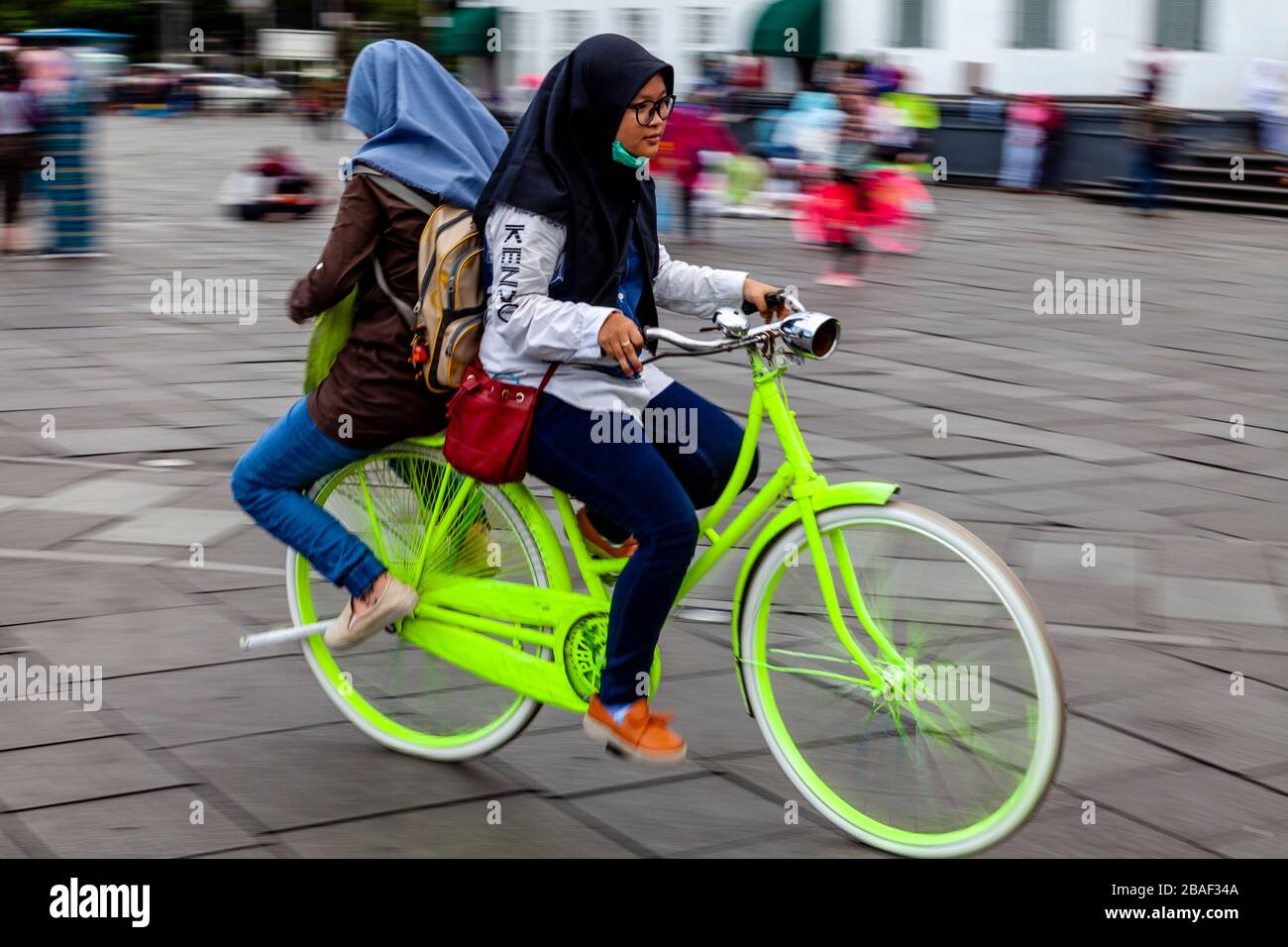 Jeunes femmes indonésiennes Cyclisme sur la place Taman Fatahillah, Jakarta, Indonésie. Banque D'Images