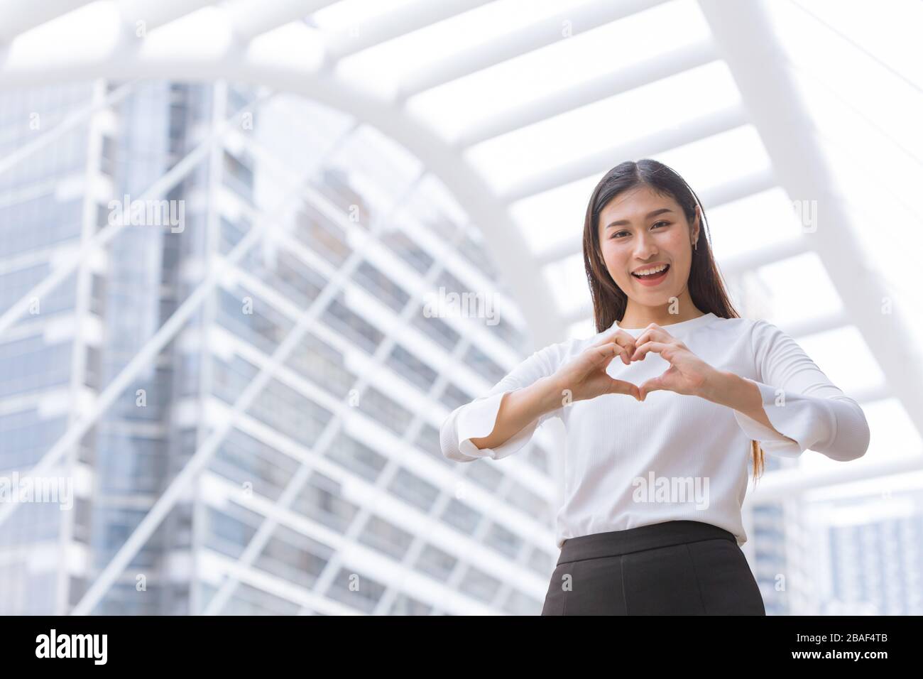 un bon service d'affaires du cœur amour soins aide et soutien concept de travail client.le personnel de la femme heureuse montre la forme et le sourire de coeur de main. Banque D'Images