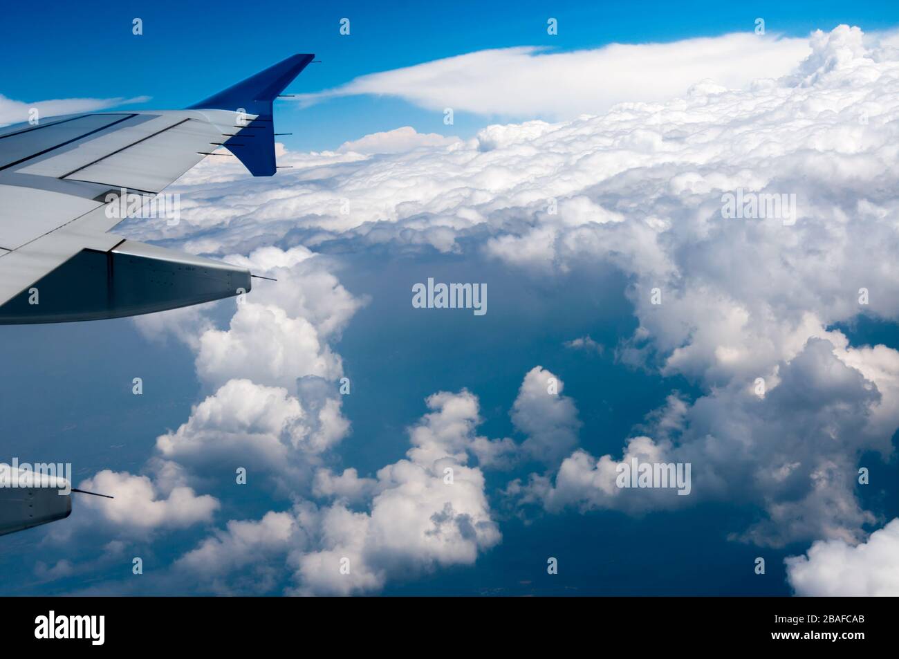Vue depuis la fenêtre de l'aile plane sous le lumière du soleil entourée de nuages en journée Banque D'Images