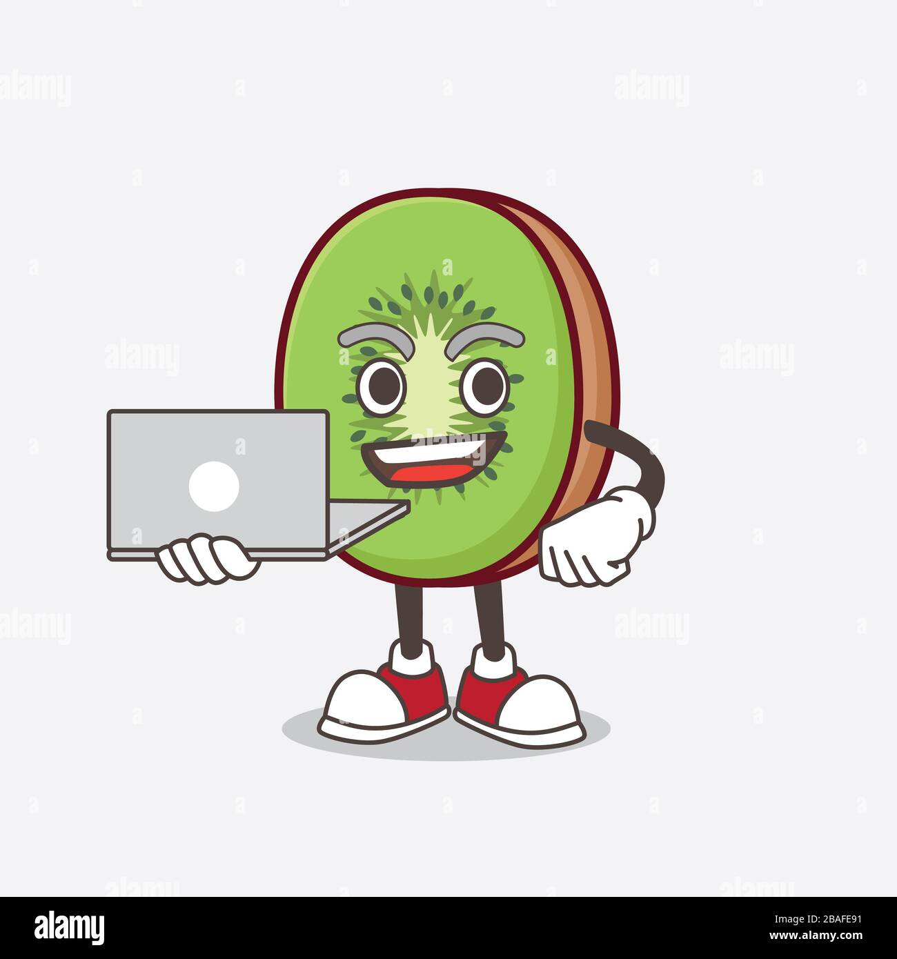 Une photo du personnage de mascotte de dessin animé Kiwi fruit qui travaille avec un ordinateur portable Banque D'Images