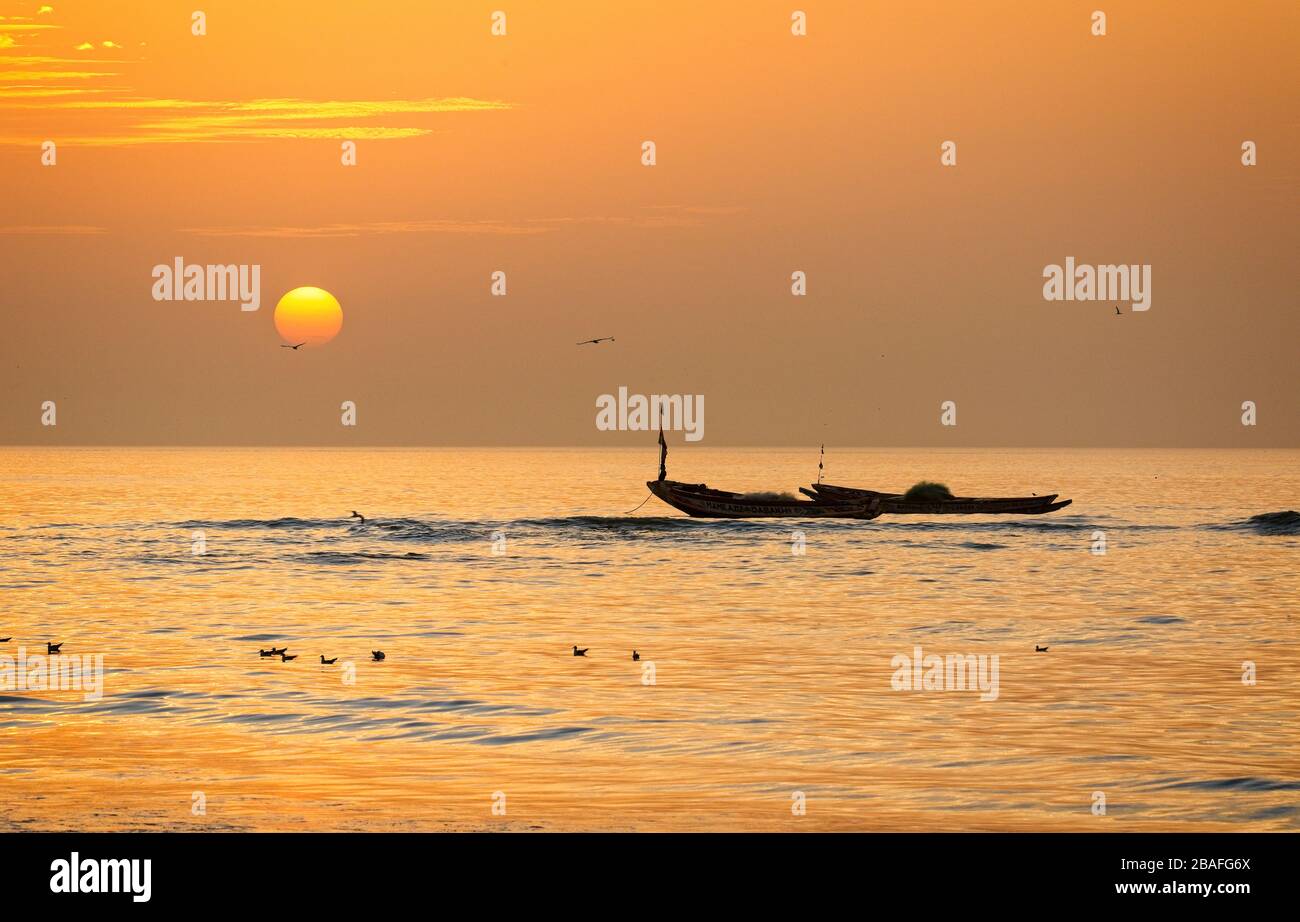 Coucher de soleil sur l'océan, avec bateaux de pêche, Tanji, Gambie. Banque D'Images