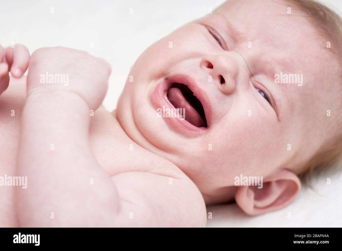 Joli bébé pleurant sur un fond clair gros plan Banque D'Images