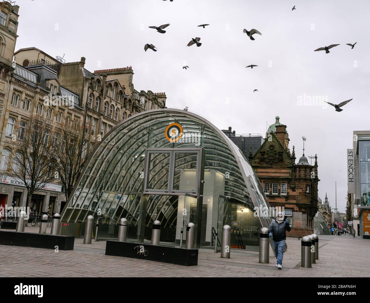 Homme marchant devant la station de métro St Enoch à Glasgow en utilisant son téléphone pour passer un appel vidéo pendant la pandémie de coronavirus au Royaume-Uni. Banque D'Images