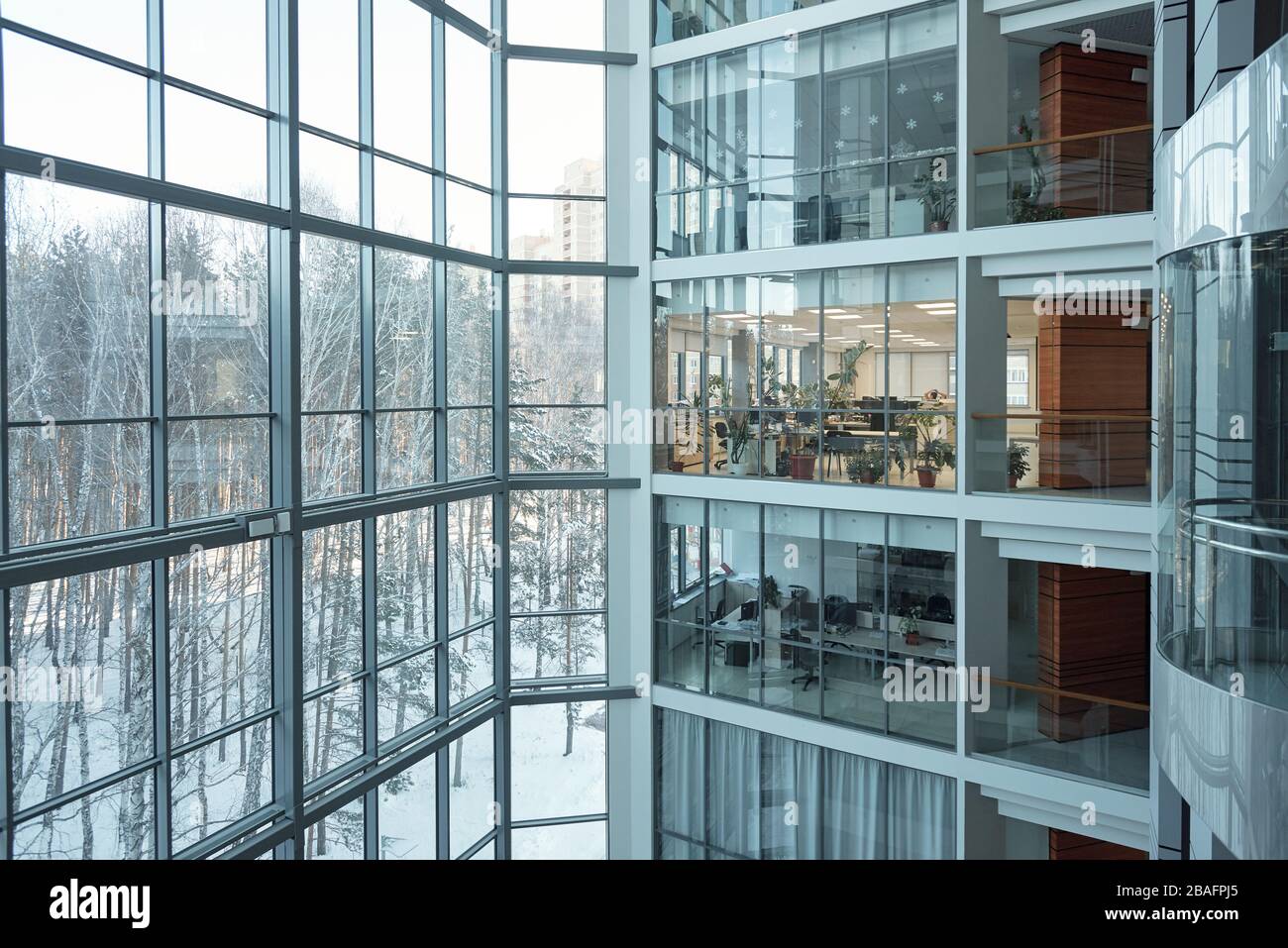 Plusieurs étages d'un grand centre d'affaires contemporain avec bureaux à espace ouvert, fenêtres, balcons et ascenseur entre eux Banque D'Images