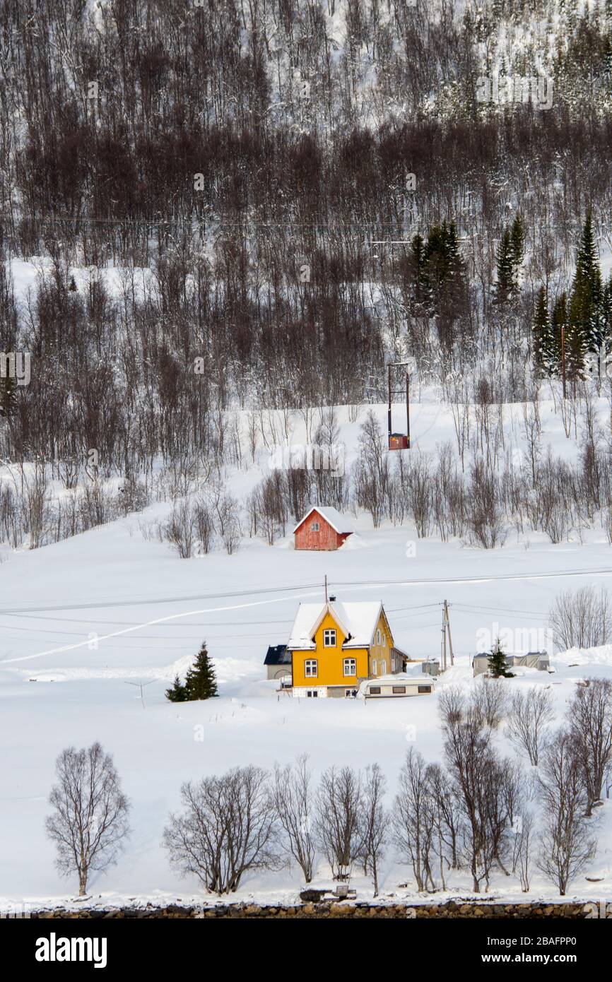 Une petite maison jaune sur la pente vallonnée du Ramfjord, un petit fjord près de la ville de Tromso dans le comté de Troms og Finnmark, Norvège. Banque D'Images