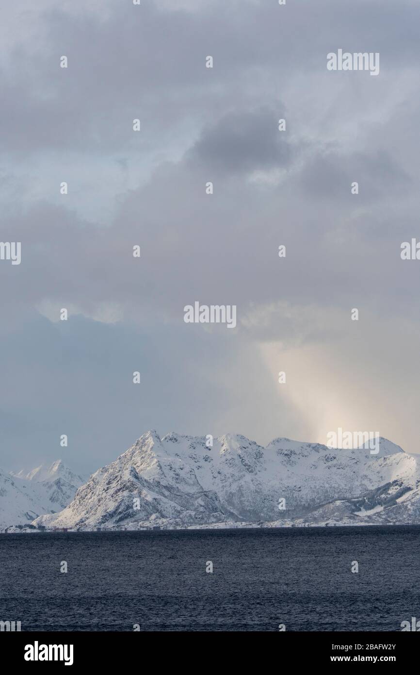 Scène d'hiver avec vue sur la mer de Norvège et les montagnes enneigées près de Henningsvaer, un petit village de pêcheurs près de Svolvaer, dans les Lofoten est Banque D'Images
