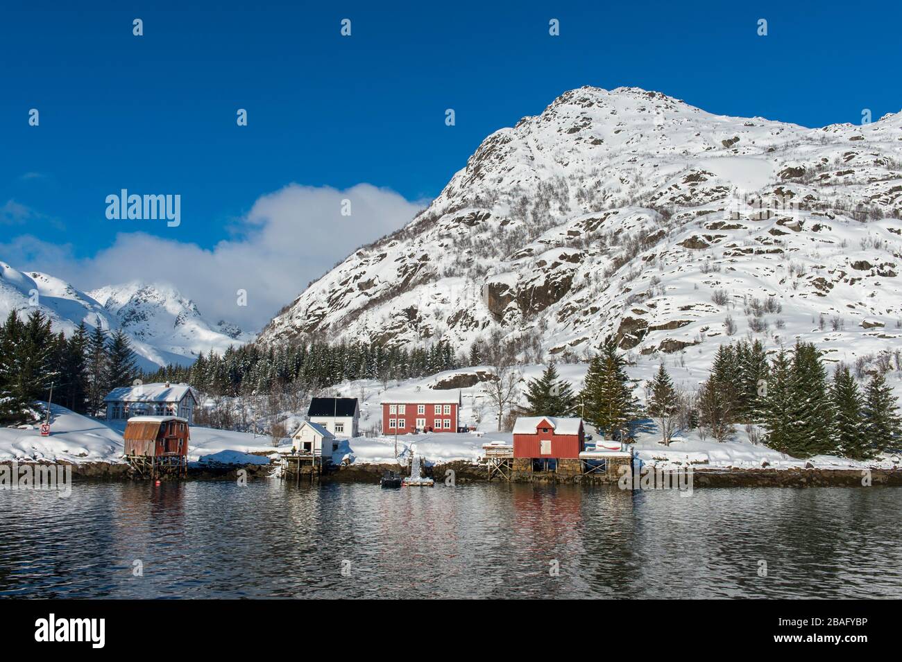 Vue sur les montagnes enneigées et les maisons de l'île d'Austvag près du célèbre Trollfjord dans les îles Lofoten, comté de Nordland, Norvège. Banque D'Images