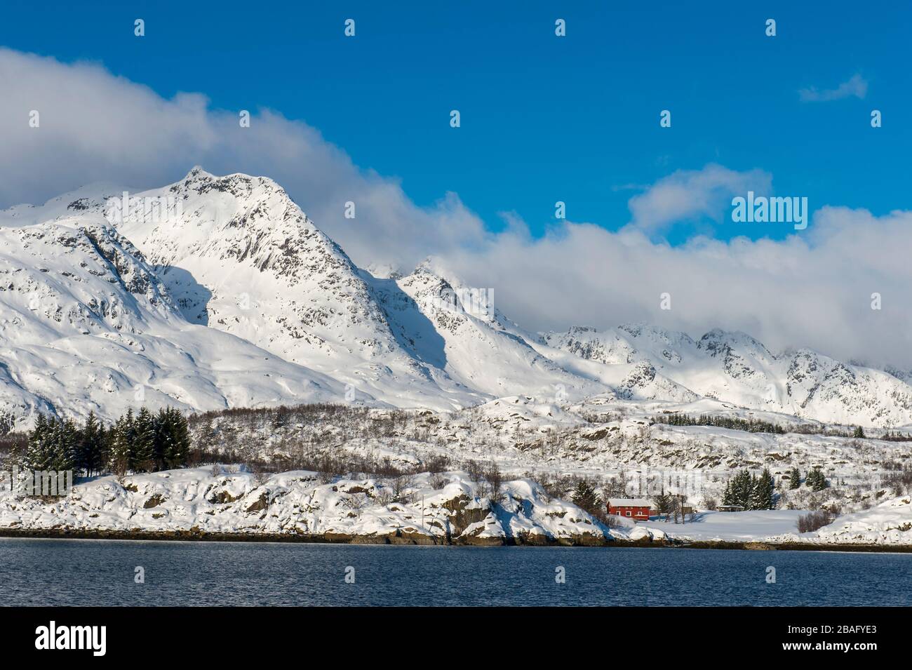 Vue sur les montagnes enneigées et les maisons de l'île d'Austvag près du célèbre Trollfjord dans les îles Lofoten, comté de Nordland, Norvège. Banque D'Images