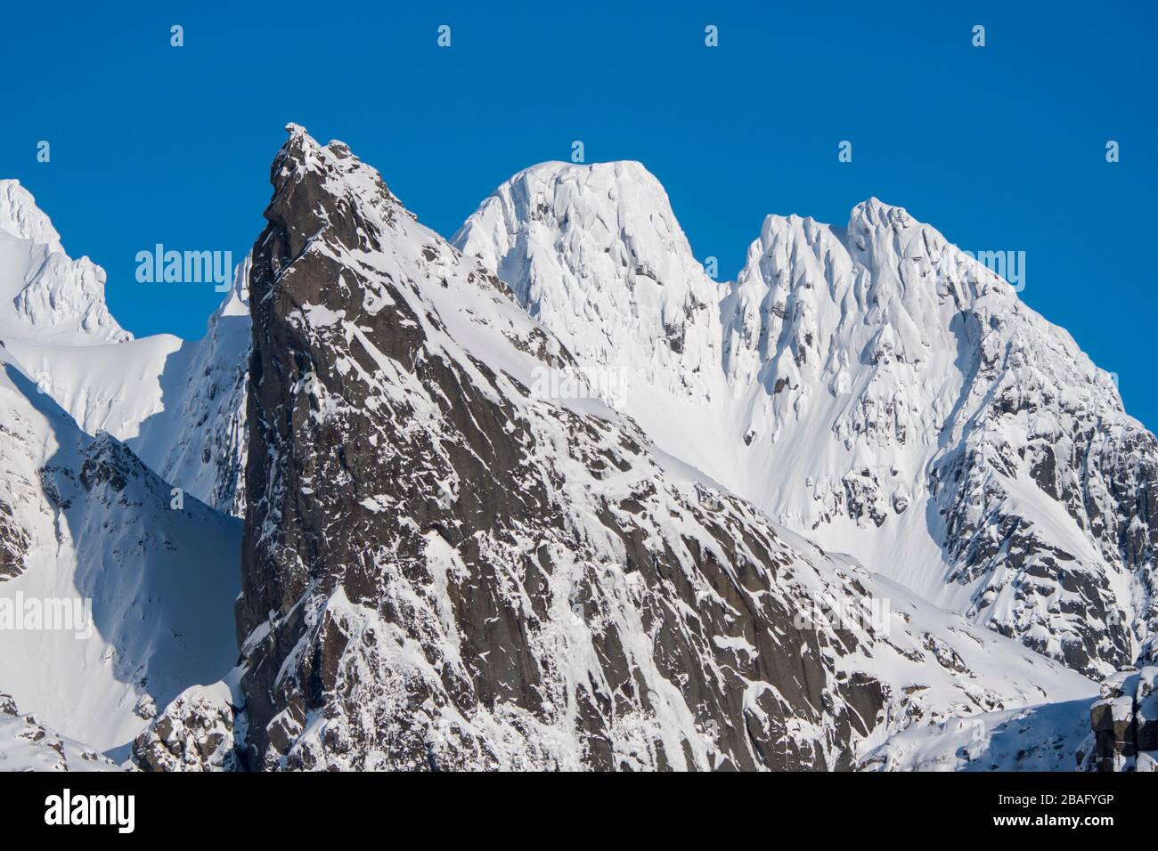 Vue sur les sommets enneigés de la montagne sur l'île d'Austvag près du célèbre Trollfjord dans les îles Lofoten, comté de Nordland, Norvège. Banque D'Images