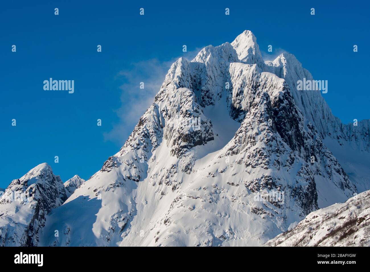 Vue sur les sommets enneigés de la montagne sur l'île d'Austvag près du célèbre Trollfjord dans les îles Lofoten, comté de Nordland, Norvège. Banque D'Images